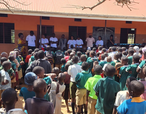 Giving out scholastic materials Kiwawu Church of Uganda Primary School