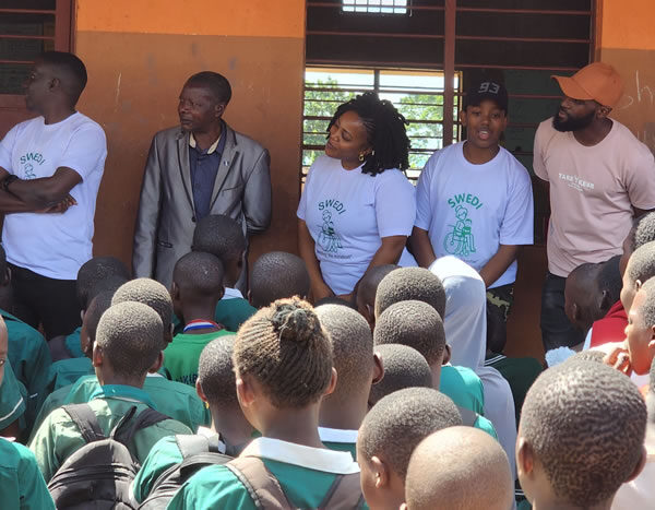 Giving out scholastic materials Kiwawu Church of Uganda Primary School