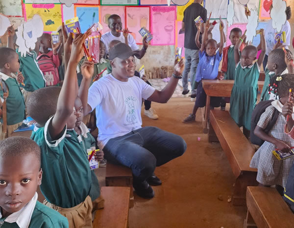 Giving out scholastic materials Kiwawu Church of Uganda Primary School